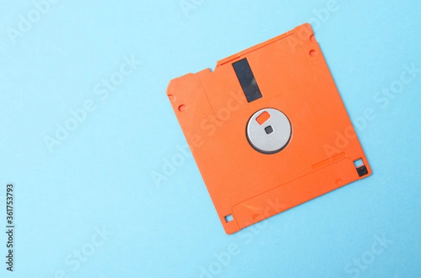Obraz Floppy orange 3.5 on a blue background. Floppy disk general plan and close-up.