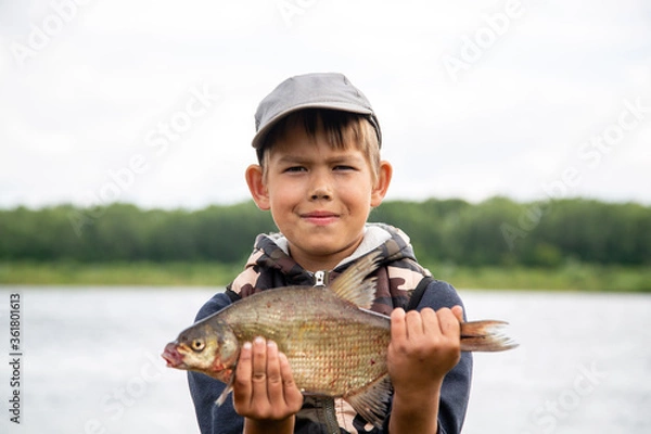 Obraz seven year old boy holds a fish he caught
