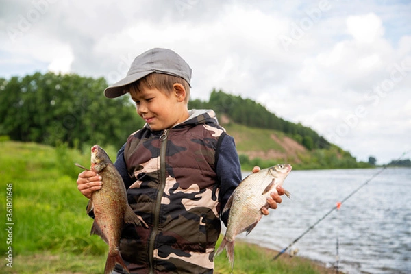 Obraz seven year old boy holds a fish he caught