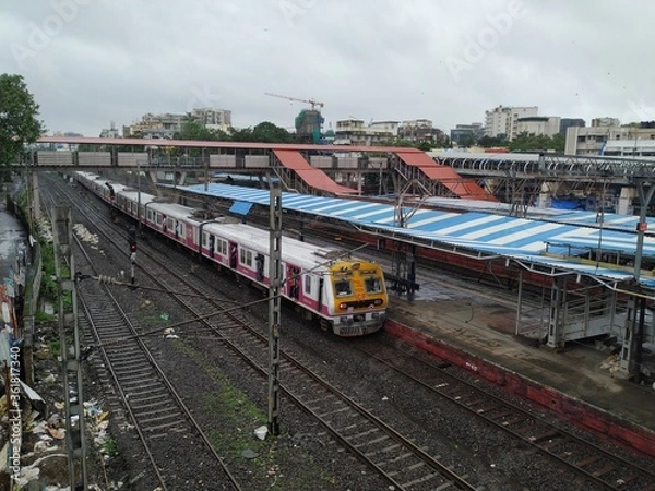Fototapeta Mumbai, Maharashtra/India- June 30 2020:  Fast local train travelling on the railway track.
