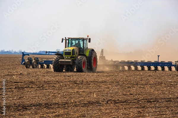 Fototapeta Farmer in tractor preparing farmland with seedbed for the next year
