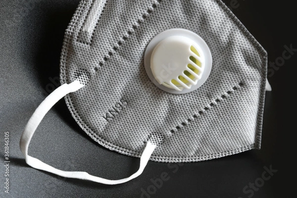 Fototapeta KN95 or N95 mask with valve for protection pm 2.5 and corona virus on black background. Prevention of the spread of virus and pandemic COVID-19.