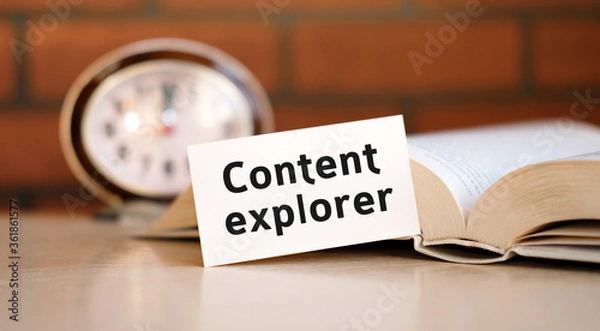 Fototapeta Content explorer concept text on a white background with a clock and an open book