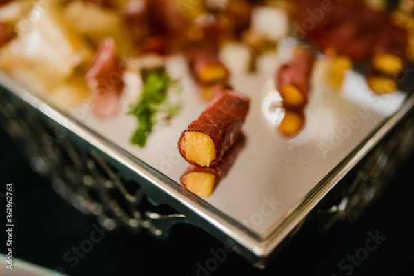 Obraz Pineapple rolled in prosciutto on a tray