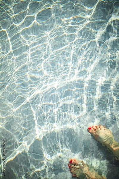 Fototapeta turquoise pool with a foot and sun reflections