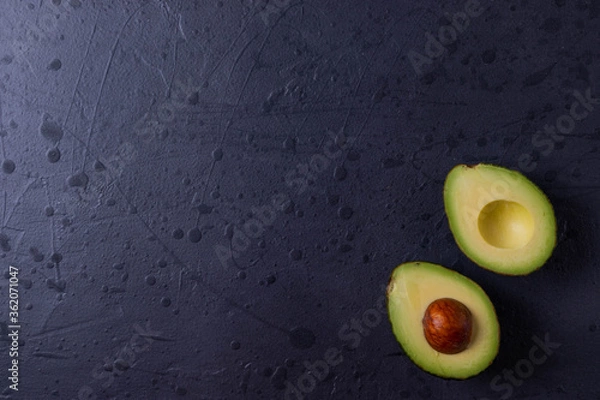 Obraz two avocado halves on dark grunge concrete surface