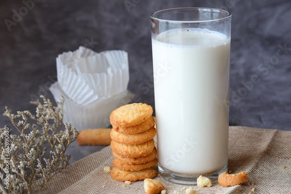 Obraz Cookies and glass of milk on a dark moody background.