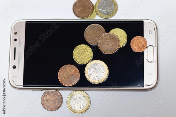 Fototapeta A smartphone with some euro coins over it