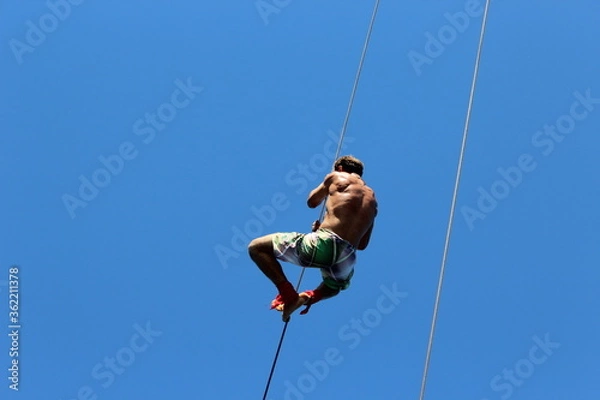 Obraz man climbing the rope