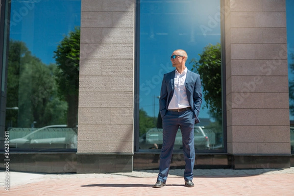 Fototapeta handsome young man in a summer suit on a walk in sunglasses