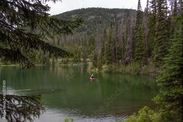 Obraz Canoeing on a green lake surrounded with mountains