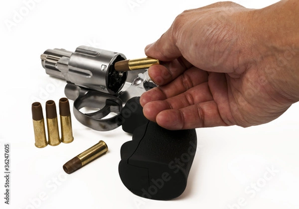 Fototapeta Put bullet into revolver gun isolated on white background