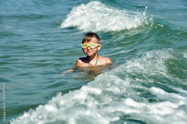 Obraz A happy boy is swimming in the sea . Children's holiday at the sea
