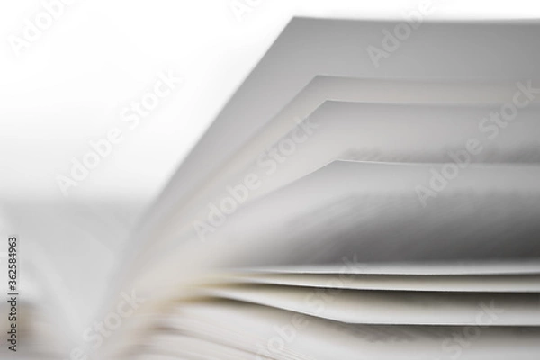 Fototapeta Open book with on the right side below pages with a sharp edge. The other pages fall outside the focus area. Very narrow depth of field