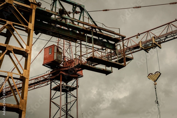 Fototapeta Old construction cranes at the construction of sky