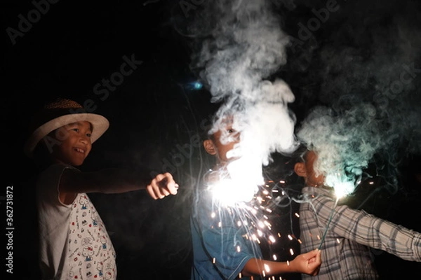 Obraz 手持ち花火を楽しむ子供たち　夏休み　アウトドア　少年少女　家族　トリオ　三兄弟