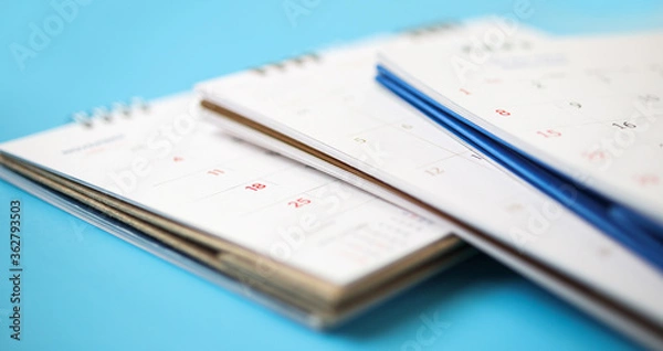 Fototapeta calendar page close up on blue background business planning appointment meeting concept