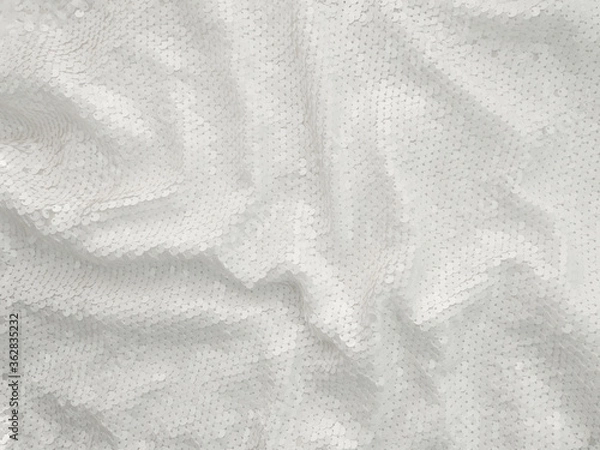 Fototapeta Background fabric sequin in white color. Holiday abstract glitter background with blinking lights. Fashion fabric glitter. 