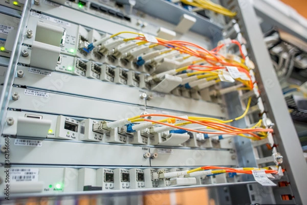 Fototapeta Server rack with red internet patch cord cables connected to patch panel in server room