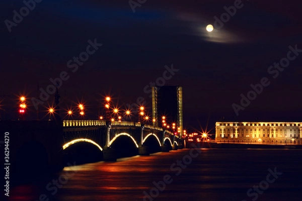 Obraz A bridge lit by lights on a moonlit night. The bridge on the Neva River in St. Petersburg.