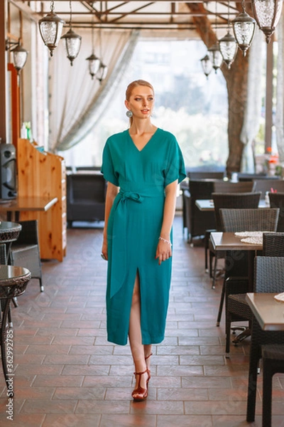 Obraz Model in a green long dress, clothing demonstration in a cafe