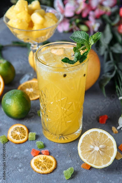 Obraz Summer fresh cold drink beverages. Ice Lemonade in the jug and lemons and orange with mint on the table outdoor. Orange lemonade in a glass