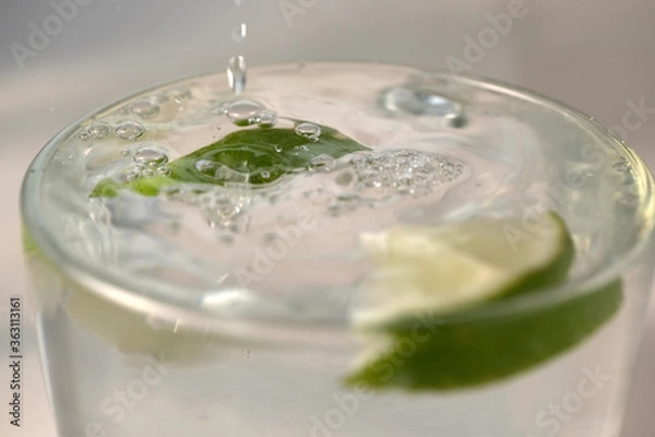 Fototapeta Refreshing lemonade with slices of lime