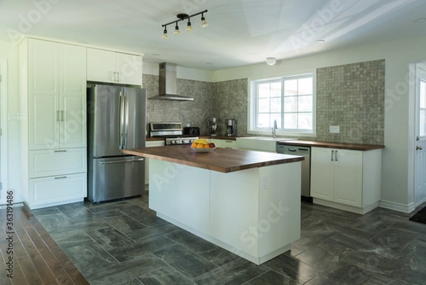 Obraz New grey and white kitchen with marble tiles, appliances and timber bench tops