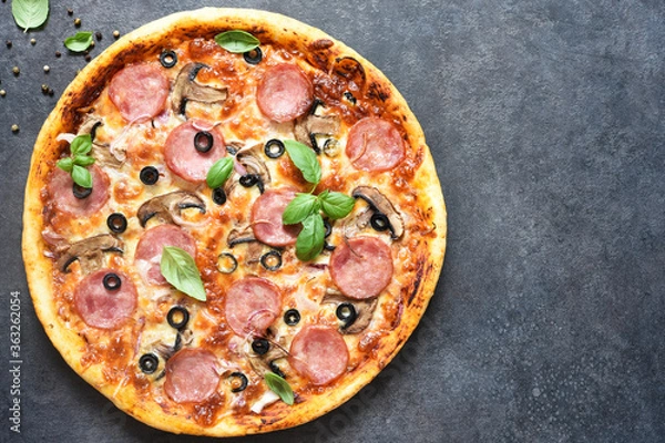 Fototapeta Pizza with salami, mushrooms and tomato sauce on a black background. View from above.