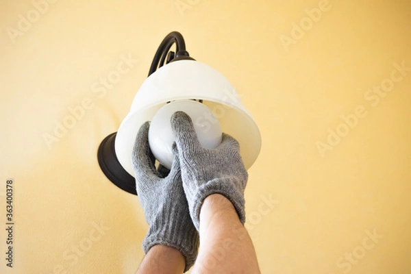 Obraz 軍手をはめてする照明の電球交換作業