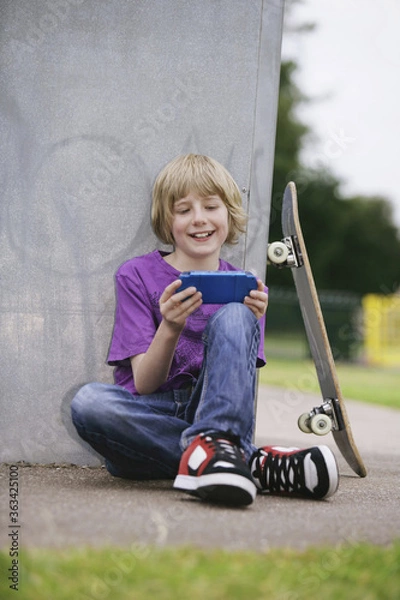 Fototapeta Boy playing with handheld video game