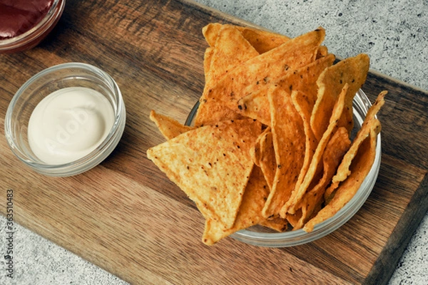 Fototapeta Corn cheese, snacks with sauce on a wooden stand. Beer snack, dish on the menu. Close up.