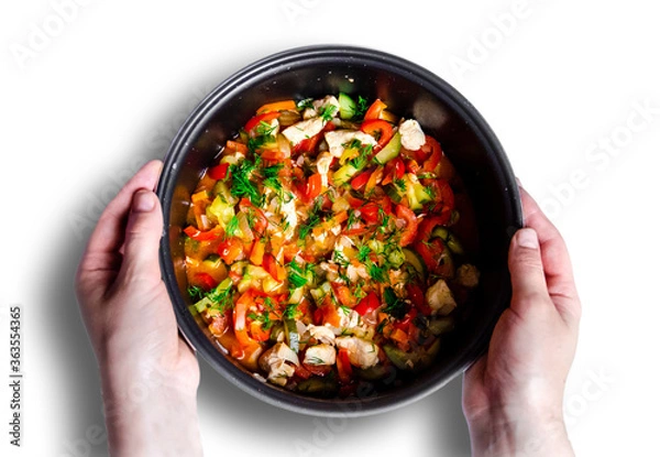 Fototapeta salad noodles and delicious tasty vegetables red bell pepper carrots cucumber dill greens tomato onion shredded fried chicken meat in a pan which hands hold on a white background top view