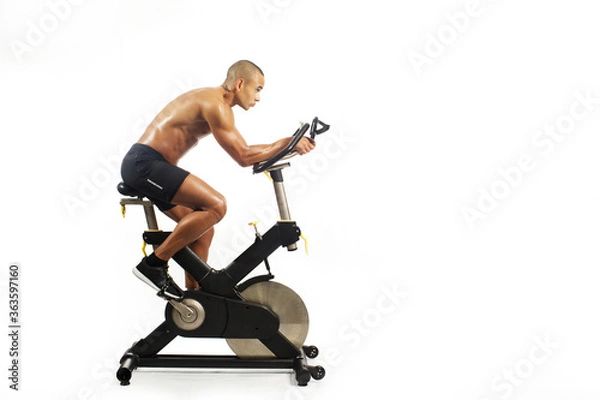 Fototapeta man on bicycle simulator doing exercises isolated on white background