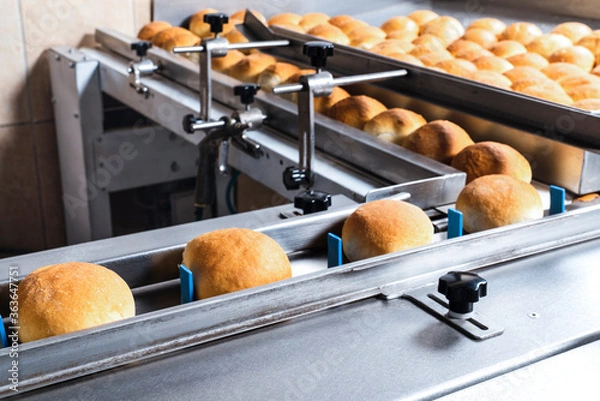 Obraz Bread packaging process on a conveyor belt