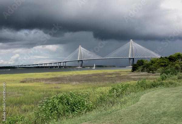 Fototapeta Storm Clouds roll in above the Arthur Ravenel Jr Bridge in Charleston, South Carolina as pleasurer  boats scurry for a safe harbor