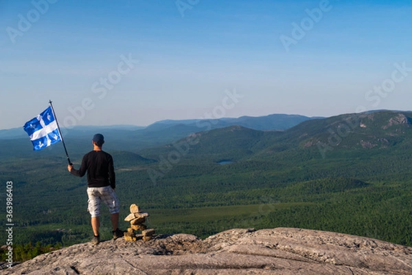 Obraz Man with a fleurdelisé flag from Quebec on the top of "La Chouenne" mountain in Charlevoix