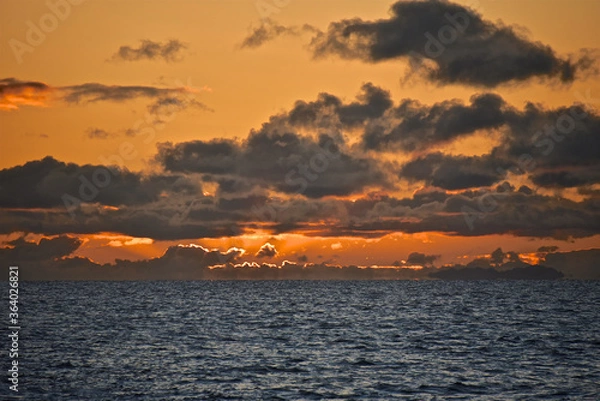 Fototapeta Autumn red sunset over the cold polar sea. Red clouds, illuminated by the cold sun, over the horizon. Photo from the side of the ship.