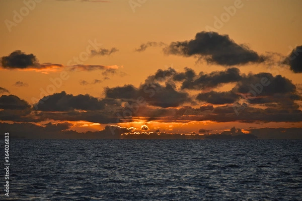 Fototapeta Autumn red sunset over the cold polar sea. Red clouds, illuminated by the cold sun, over the horizon. Photo from the side of the ship.