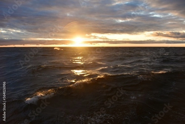 Fototapeta Low sun over the North Sea. Fall. Cold evening. Marine species. Photo from the side of the ship.