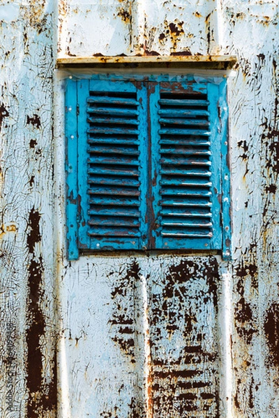 Fototapeta Old wooden window painted blue with rusty lock. Texture, wall of an old wooden house with shuttered windows, painted blue. 