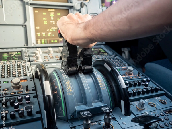 Fototapeta pilot hand on thrust lever in A320 aircraft. warm sunlight in cockpit. Concept of power.