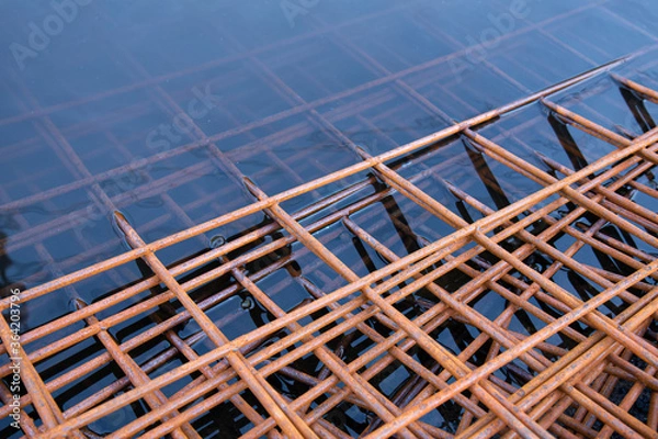 Obraz The rusty steel grid in pattern,Rusty construction metal mesh. Rusty Metal armature net for  road infrastructure  metal rebar for construction,Sites Soak in Water and Rust.