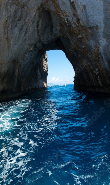 Fototapeta The grotto passing trought the Faraglioni of Capri iland, located on the Italian south seaside next to Naples.