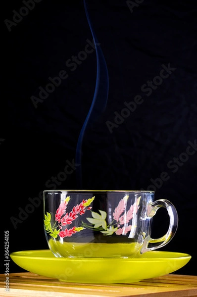 Obraz Glass cup with a floral pattern on a green saucer. Сurly smoke