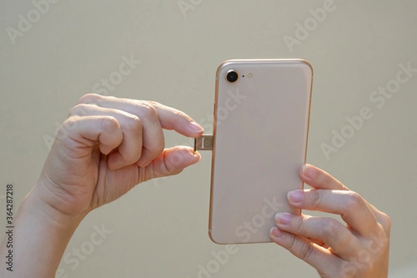 Fototapeta SIMカードをスマートフォンに差し込んで起動するイメージ