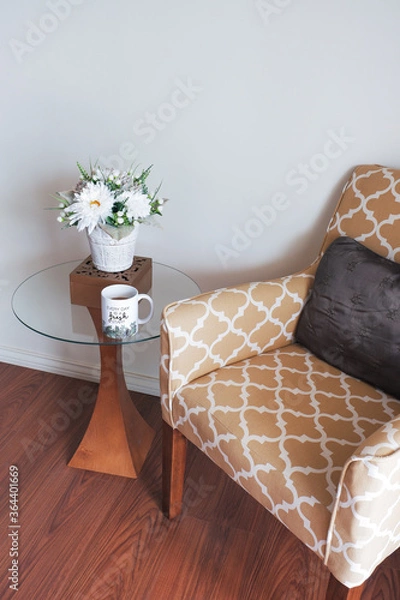 Fototapeta Cozy corner with arm chair, table, flower pot and coffee mug with inspirational message - background