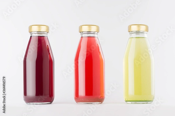 Fototapeta Red, pink, green fruit juices collection in glass bottles with cap in row mock up on white background, template for packaging, advertising, design product, branding.