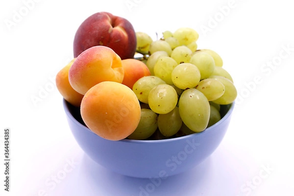 Fototapeta Grape bunch, peaches and apricot close-up on a white background