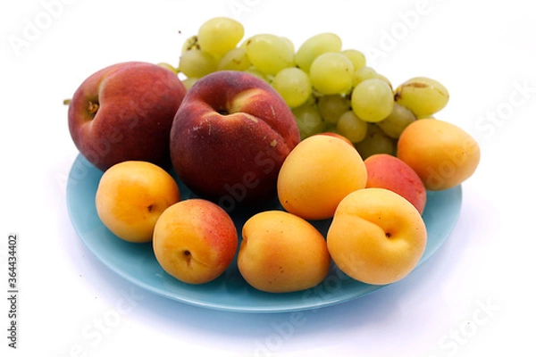 Fototapeta Grape bunch, peaches and apricot close-up on a white background